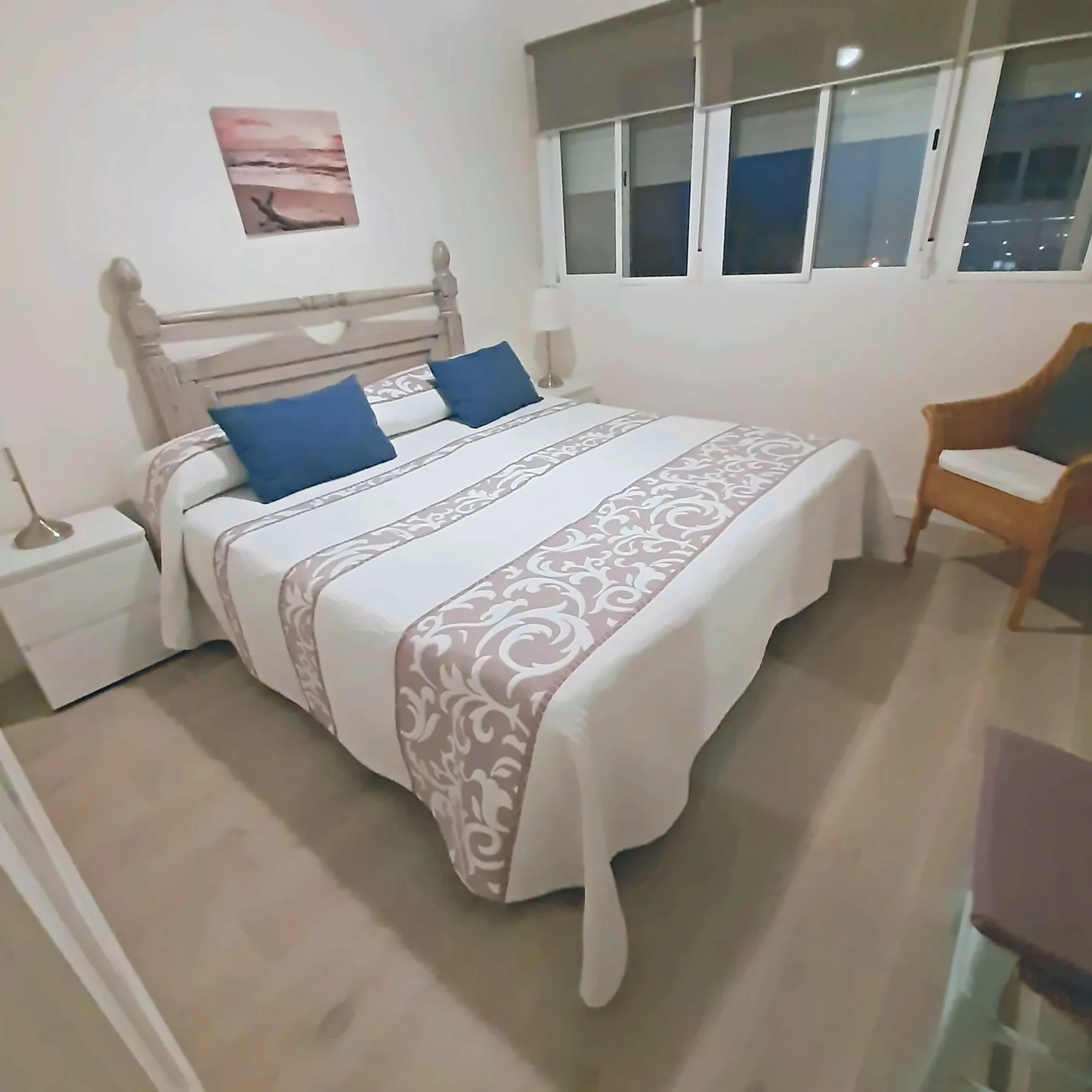 Dormitorio principal con butaca y ventanal