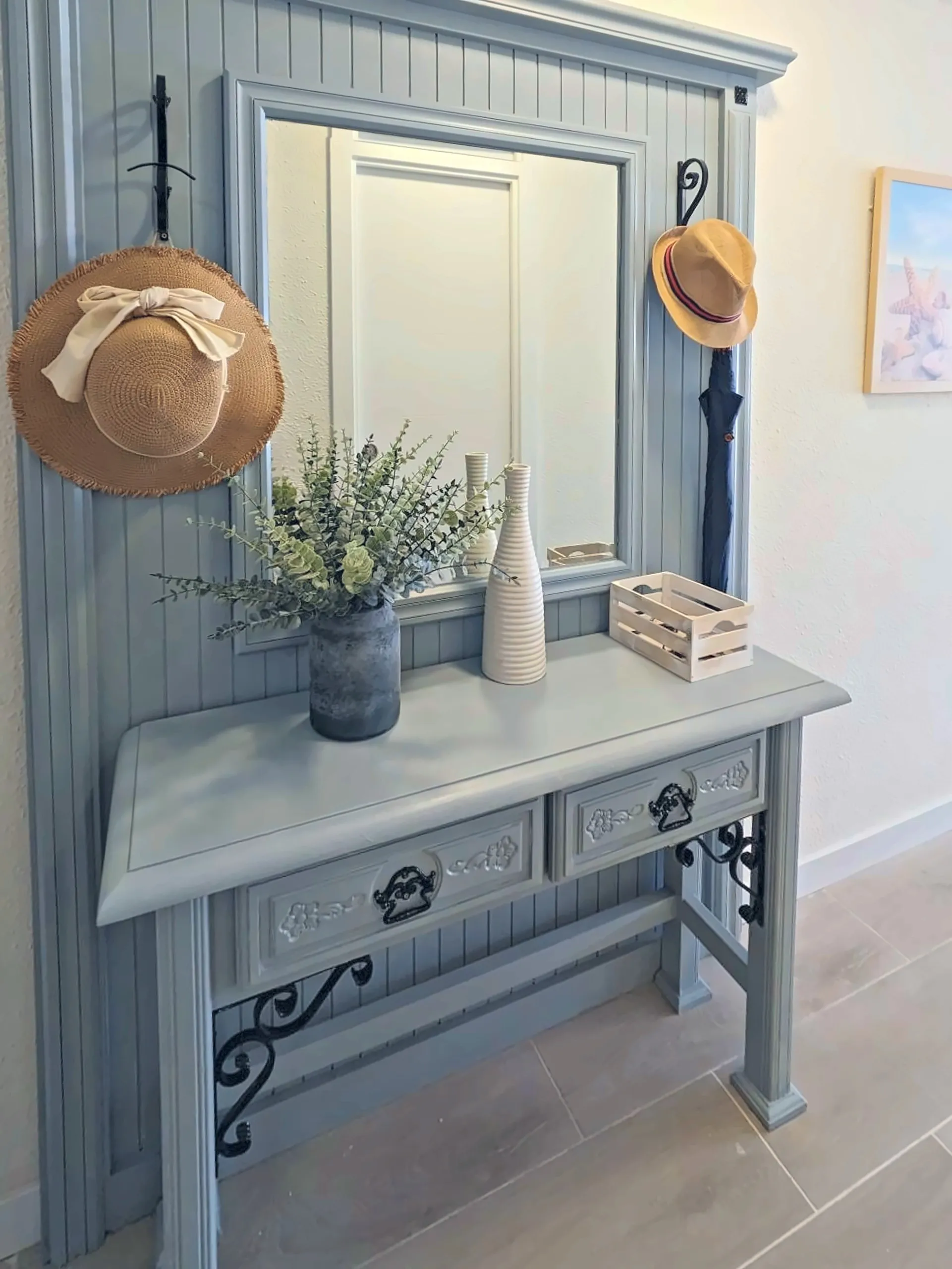 Recibidor con mueble, espejo y sombreros de playa