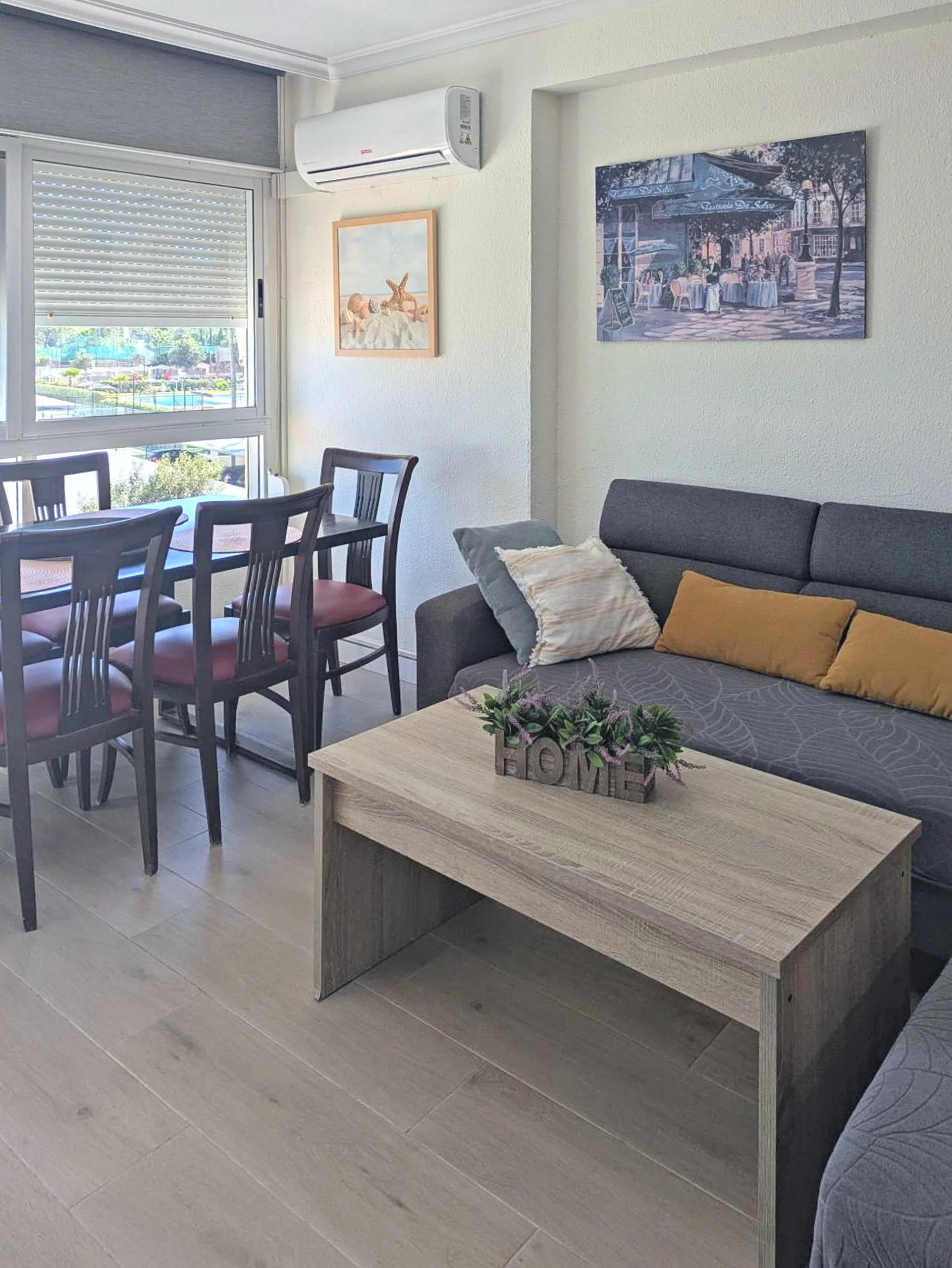 Salón con sofá, mesa de comedor y aire acondicionado