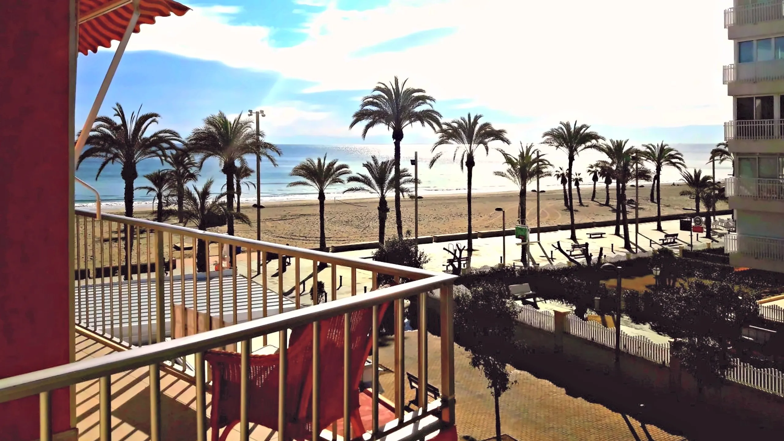 Palmeras, playa y mar desde el balcón del apartamento